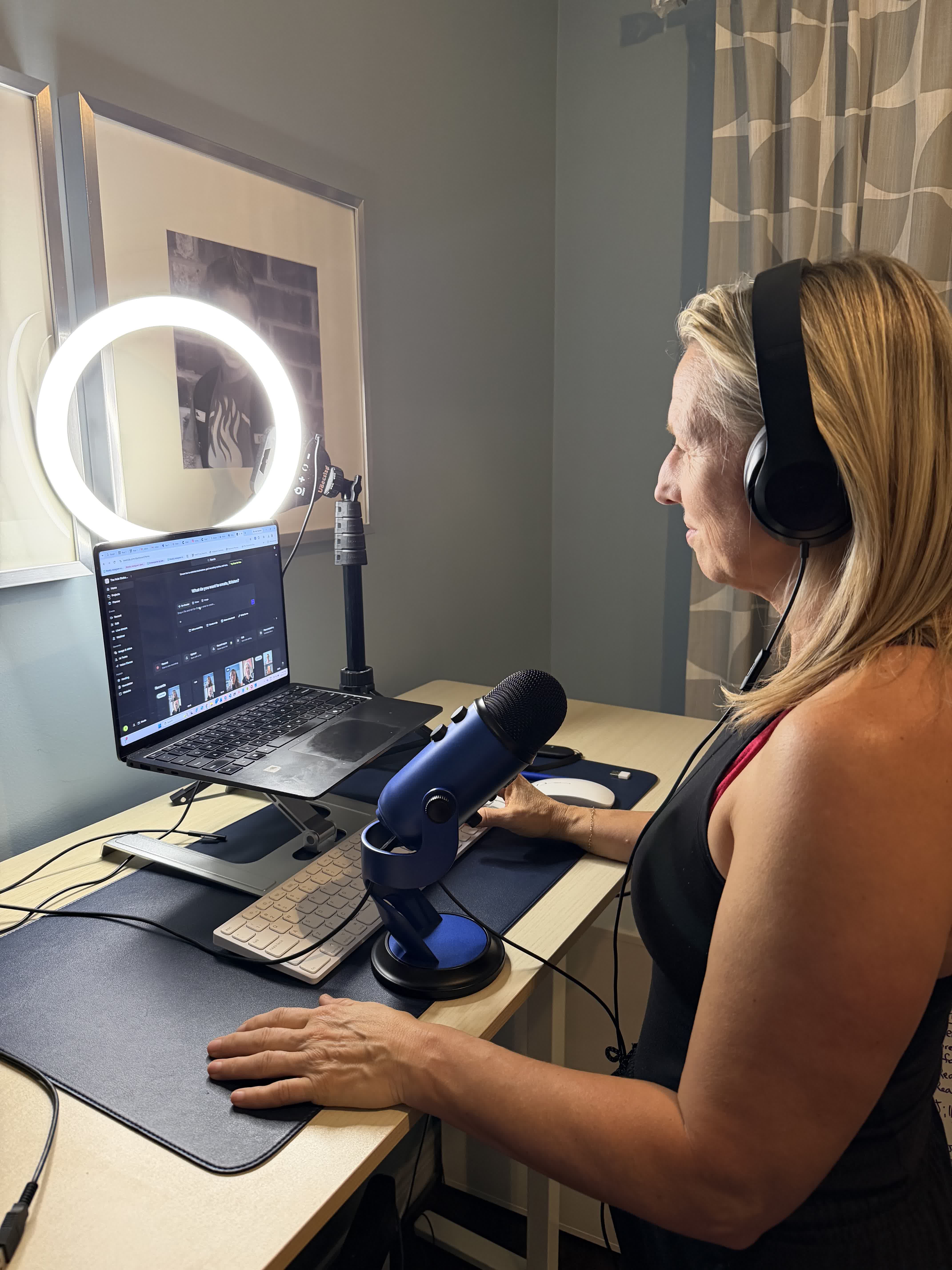 Kristen at her podcast recording desk with headphones and microphone
